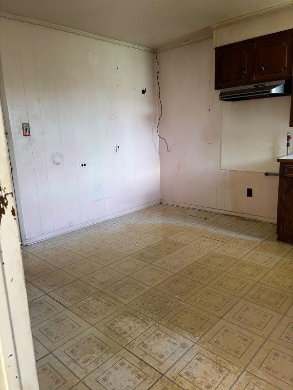 1228 Cypress St, Baytown, TX 77520 - empty room featuring baseboards, light flooring, and wood walls