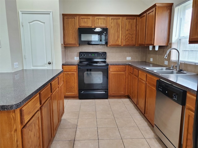 kitchen with light tile patterned flooring, a sink, decorative backsplash, brown cabinets, and black appliances