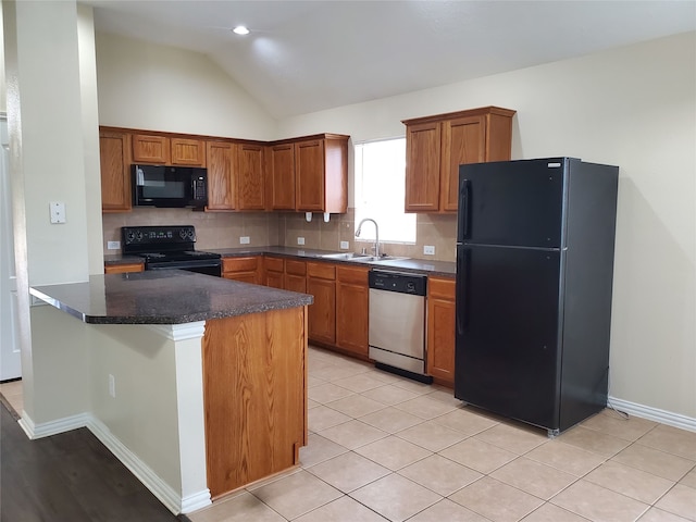 kitchen with decorative backsplash, dark countertops, lofted ceiling, a sink, and black appliances
