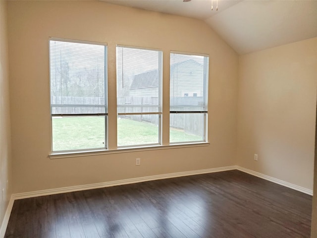 empty room featuring dark wood-style floors, lofted ceiling, ceiling fan, and baseboards