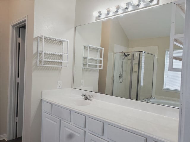 bathroom featuring lofted ceiling, a stall shower, and vanity