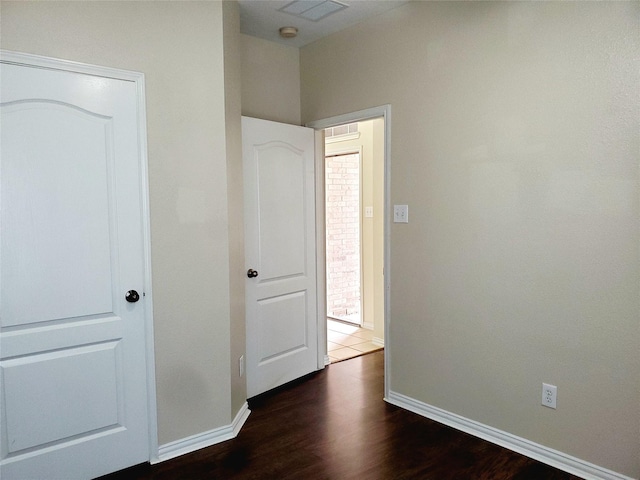 unfurnished bedroom featuring baseboards, visible vents, and wood finished floors