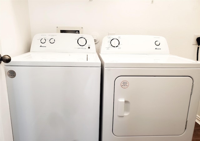 clothes washing area with laundry area, wood finished floors, and independent washer and dryer