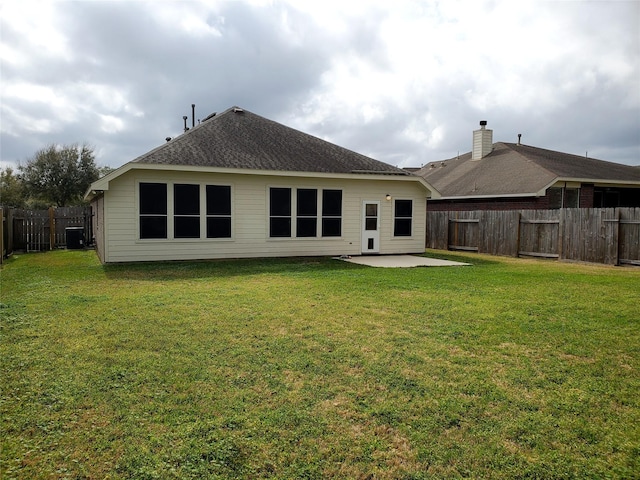 rear view of house featuring central AC unit, a lawn, a patio area, and a fenced backyard