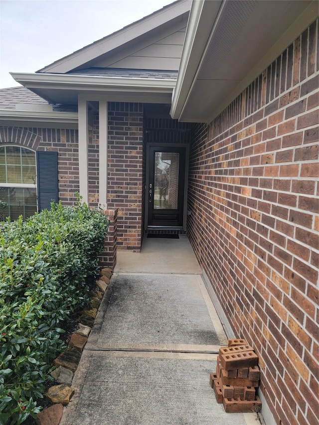 view of exterior entry with brick siding