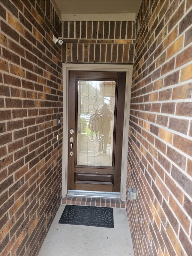 property entrance featuring brick siding