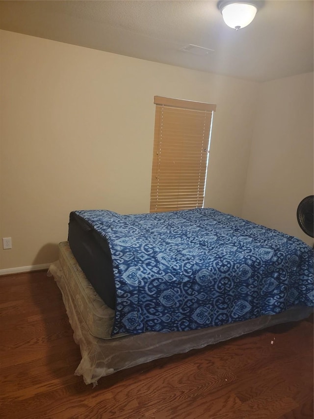 bedroom featuring baseboards and wood finished floors