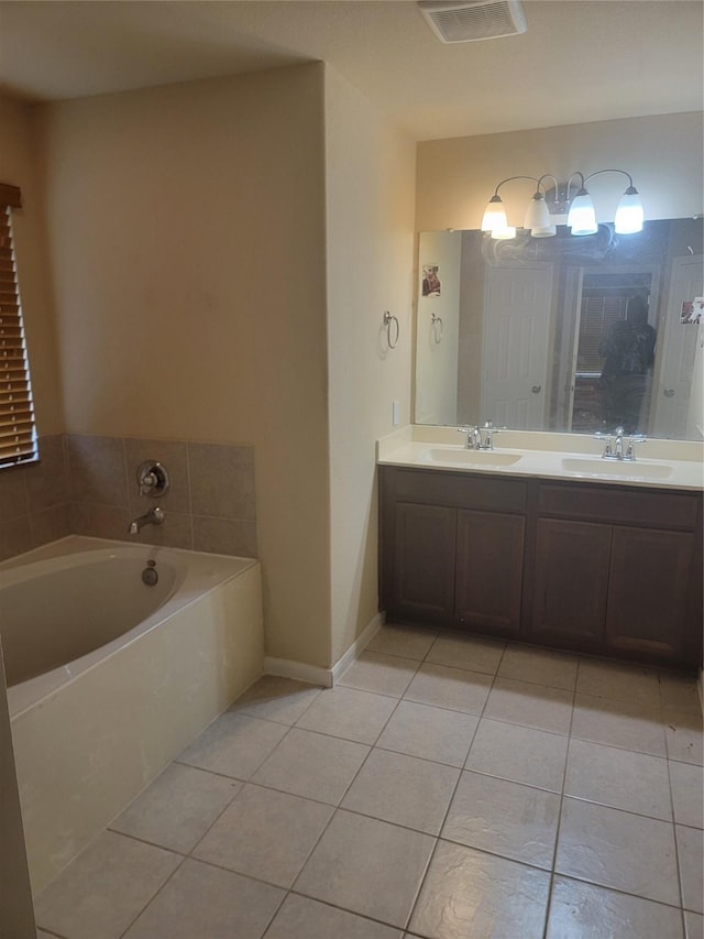 full bath with double vanity, a garden tub, a sink, and tile patterned floors