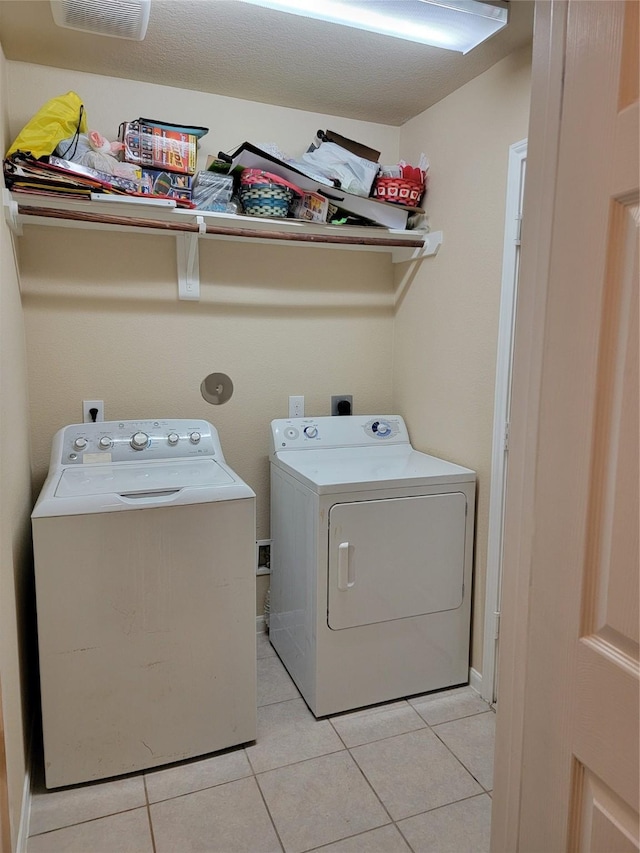 laundry area featuring light tile patterned floors, laundry area, and washing machine and clothes dryer