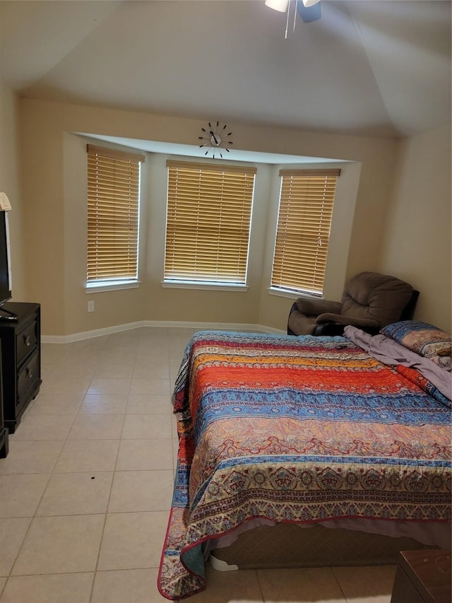 bedroom featuring vaulted ceiling, light tile patterned flooring, and baseboards