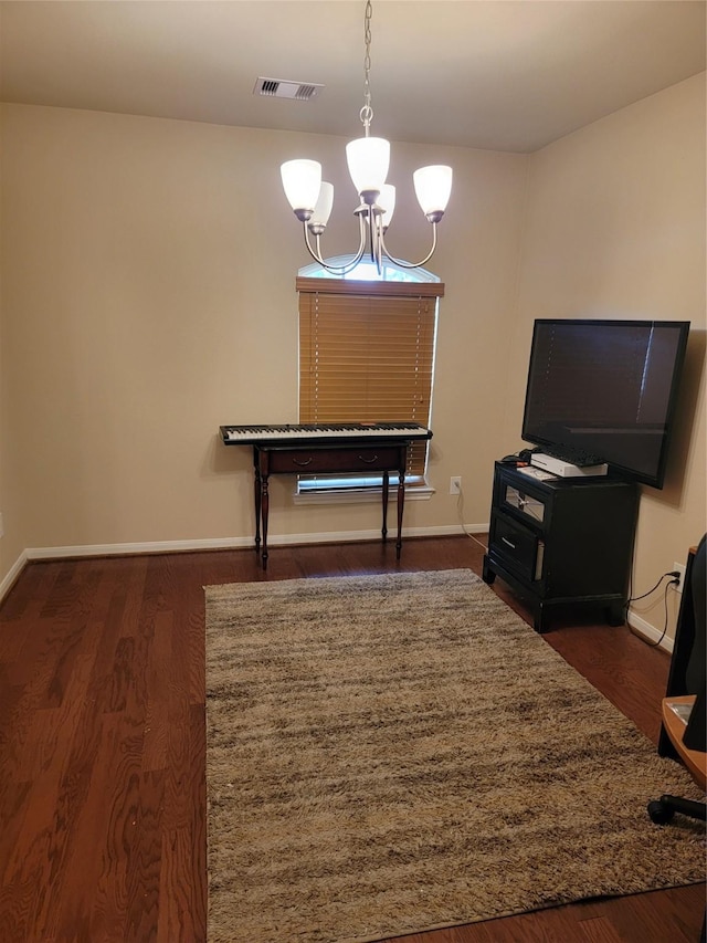 interior space with dark wood-style flooring, visible vents, baseboards, and an inviting chandelier