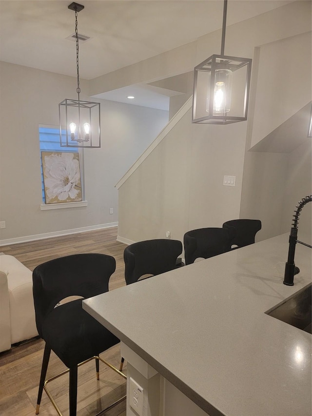 dining area with light wood-type flooring, visible vents, baseboards, and stairs