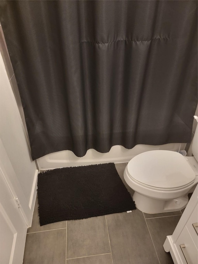 bathroom with toilet, a shower with shower curtain, and tile patterned floors