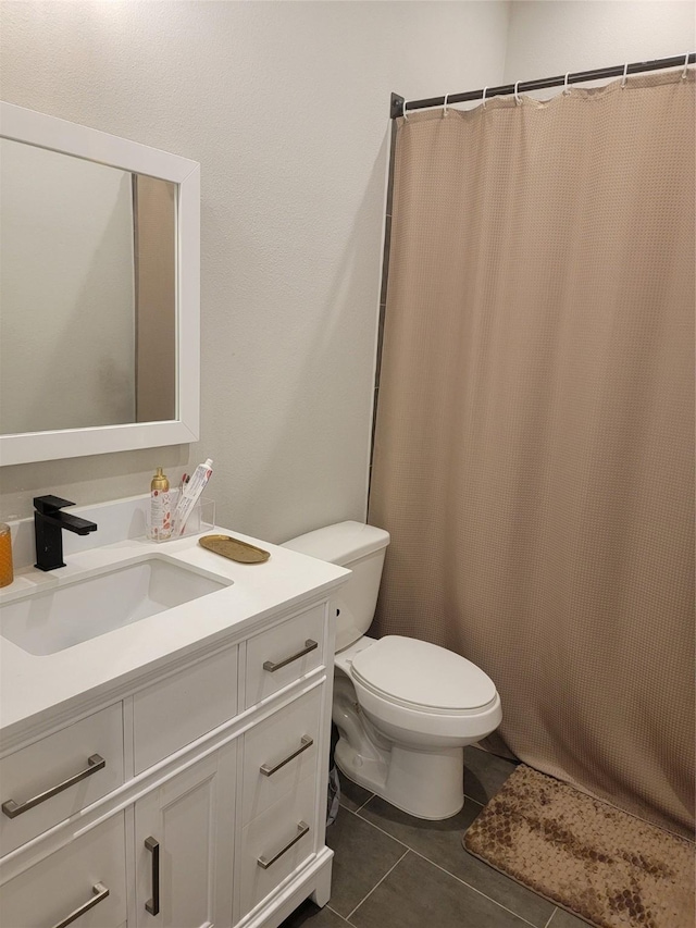 bathroom featuring toilet, vanity, and tile patterned floors