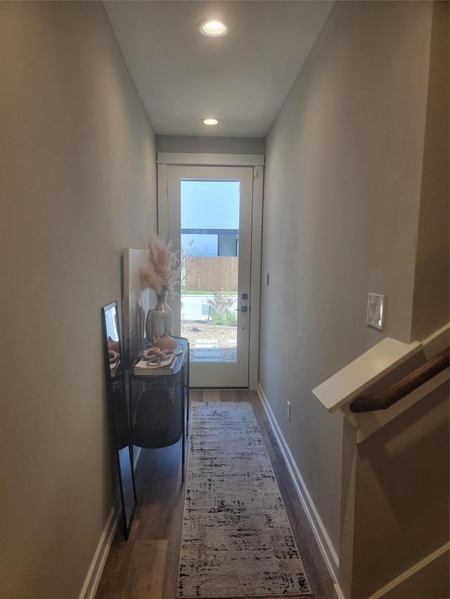 doorway with wood finished floors and baseboards