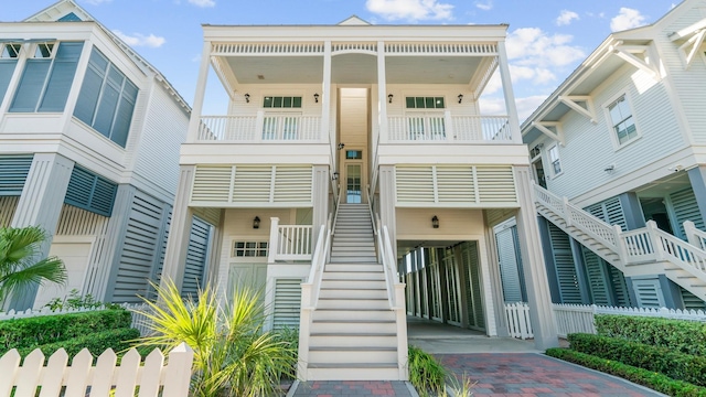 view of property with stairway and decorative driveway