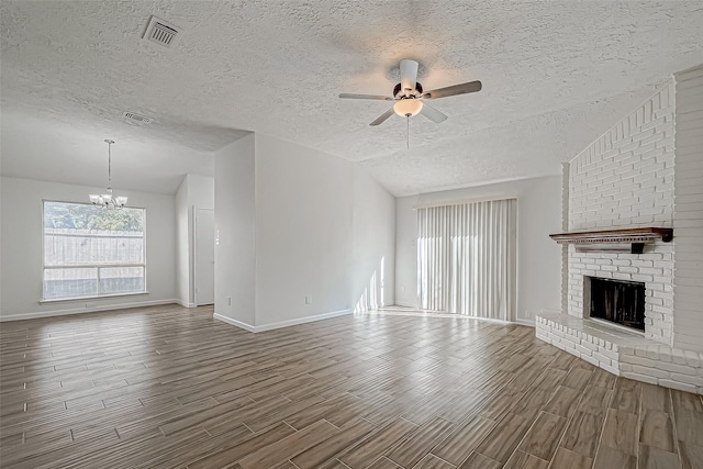 unfurnished living room featuring wood tiled floor, vaulted ceiling, visible vents, and a fireplace