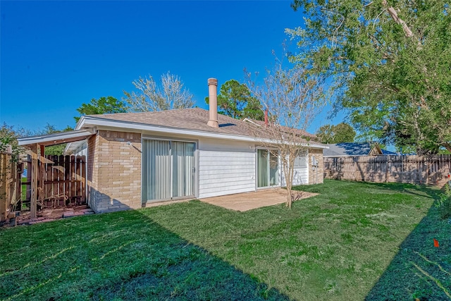 back of property featuring a patio area, fence, a lawn, and brick siding