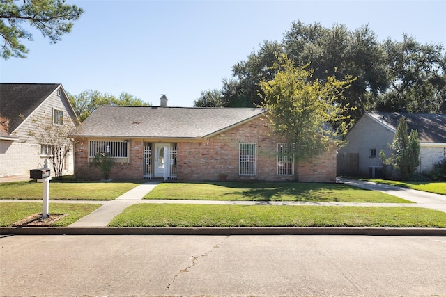 single story home featuring a front yard, brick siding, and a chimney