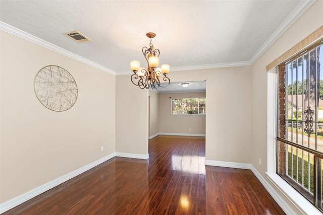 unfurnished room featuring an inviting chandelier, wood finished floors, visible vents, and baseboards