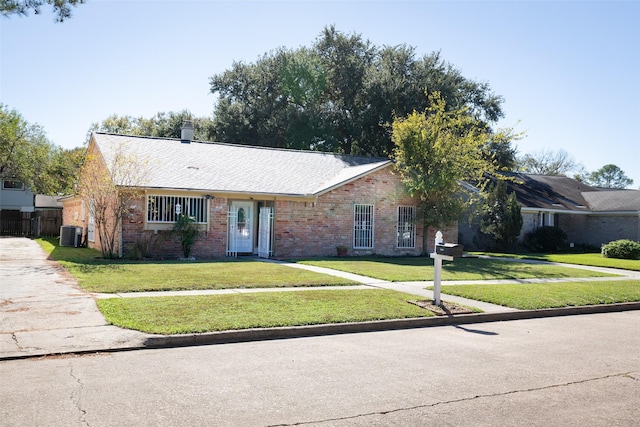 single story home featuring brick siding, fence, central AC, and a front yard