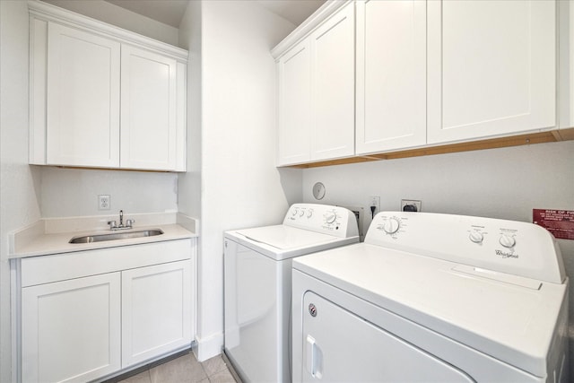 laundry room with light tile patterned floors, a sink, cabinet space, and washer and dryer