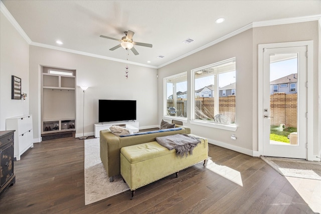 living room with dark wood-type flooring, visible vents, crown molding, and baseboards