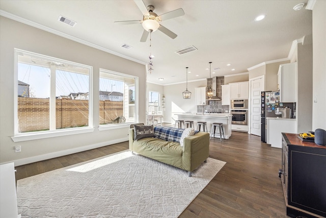 living area featuring dark wood-style flooring, visible vents, and baseboards