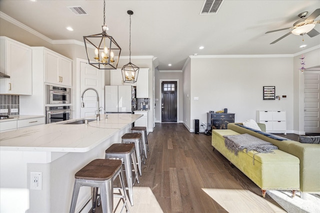 kitchen with visible vents, dark wood-type flooring, backsplash, and freestanding refrigerator