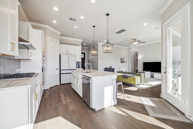 kitchen with appliances with stainless steel finishes, visible vents, extractor fan, and a sink