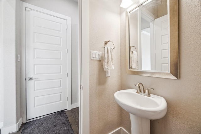 bathroom featuring a sink and a textured wall