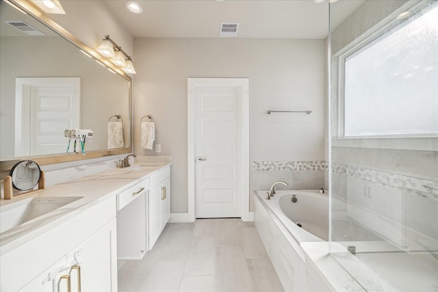 full bath featuring visible vents, a garden tub, a sink, and double vanity