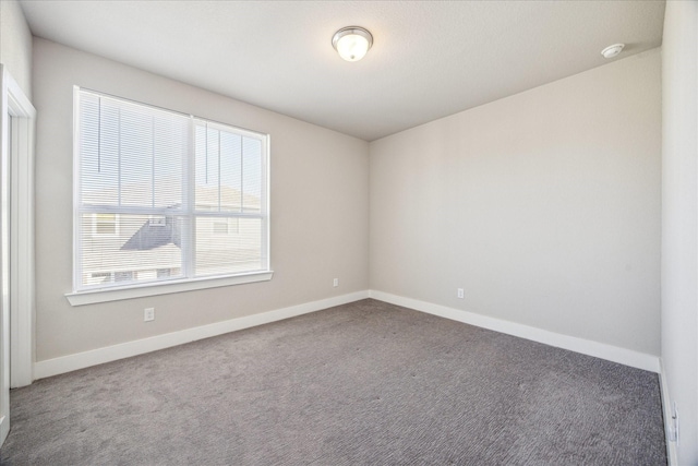 empty room featuring carpet flooring and baseboards