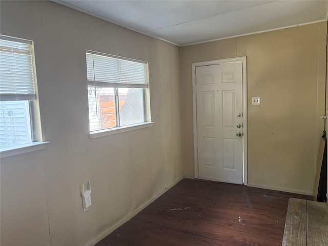 foyer featuring baseboards and wood finished floors