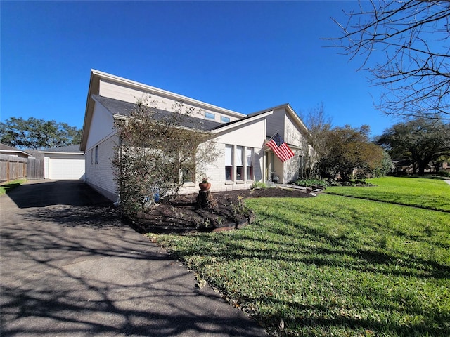 view of side of home featuring a lawn and fence