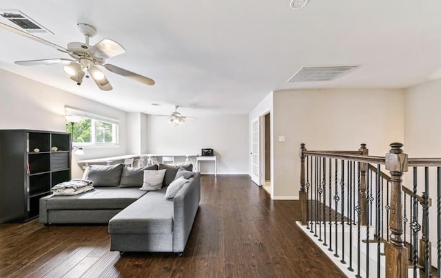 living area featuring visible vents, baseboards, and wood finished floors