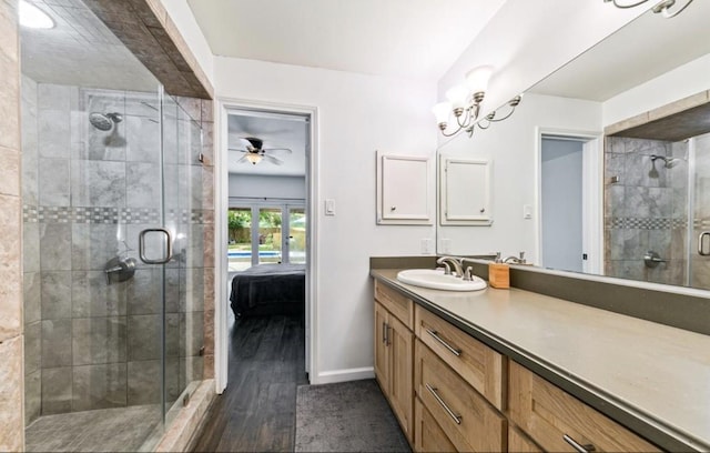 ensuite bathroom featuring baseboards, ensuite bath, wood finished floors, vanity, and a shower stall