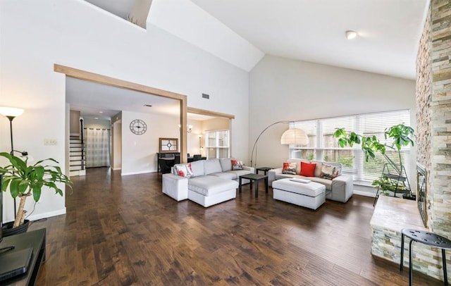 living room featuring stairway, a fireplace, high vaulted ceiling, and wood finished floors