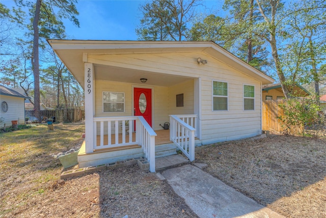 view of front of home with covered porch and fence