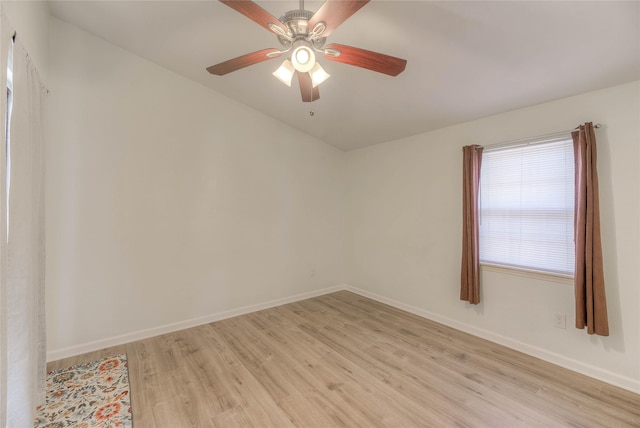 spare room featuring baseboards, ceiling fan, and light wood-style floors