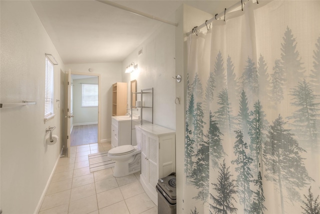 bathroom featuring toilet, vanity, baseboards, and tile patterned floors