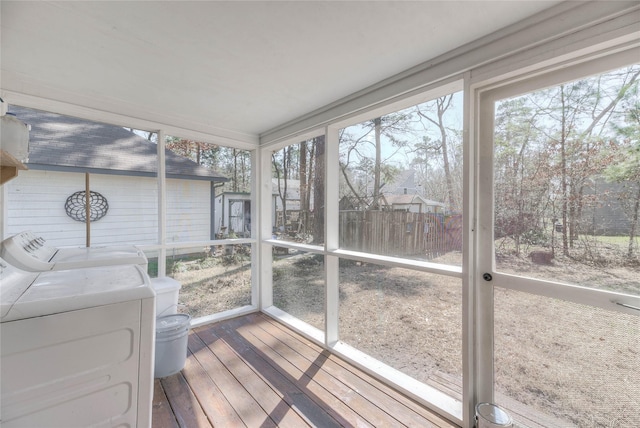 unfurnished sunroom featuring a healthy amount of sunlight and separate washer and dryer