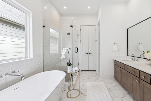 bathroom featuring a soaking tub, marble finish floor, vanity, a shower stall, and recessed lighting