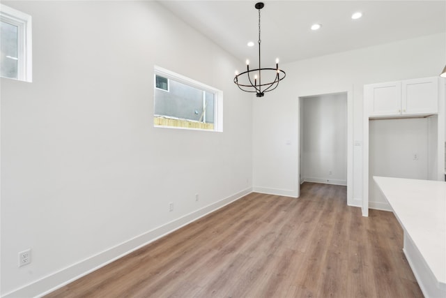 unfurnished dining area featuring visible vents, baseboards, an inviting chandelier, light wood-type flooring, and recessed lighting