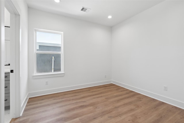 unfurnished room featuring light wood-style floors, recessed lighting, visible vents, and baseboards