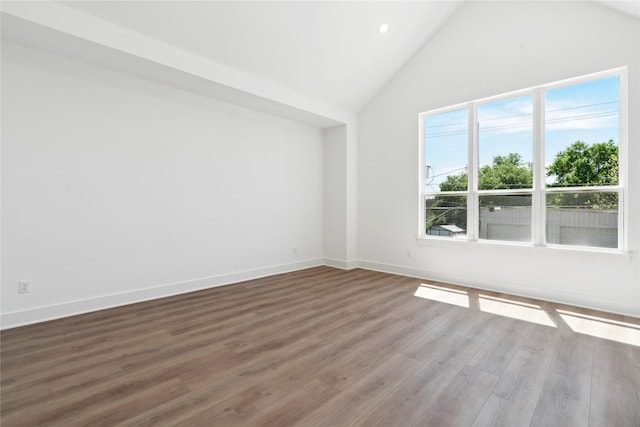 unfurnished room featuring high vaulted ceiling, wood finished floors, and baseboards