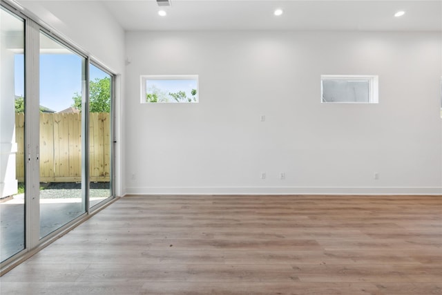 spare room with baseboards, light wood-style floors, and recessed lighting