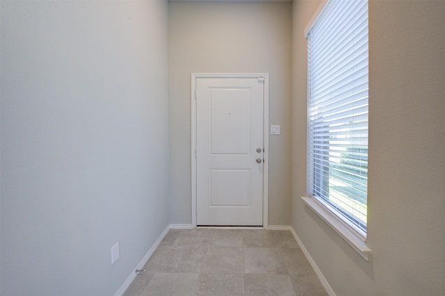 entryway with light tile patterned floors and baseboards