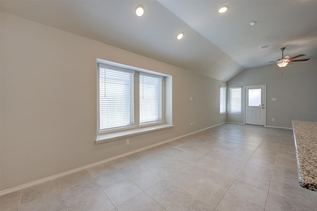 spare room featuring light tile patterned floors, baseboards, visible vents, a ceiling fan, and lofted ceiling