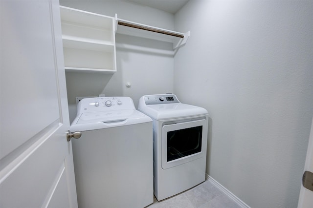 laundry room featuring laundry area, light tile patterned floors, baseboards, and independent washer and dryer